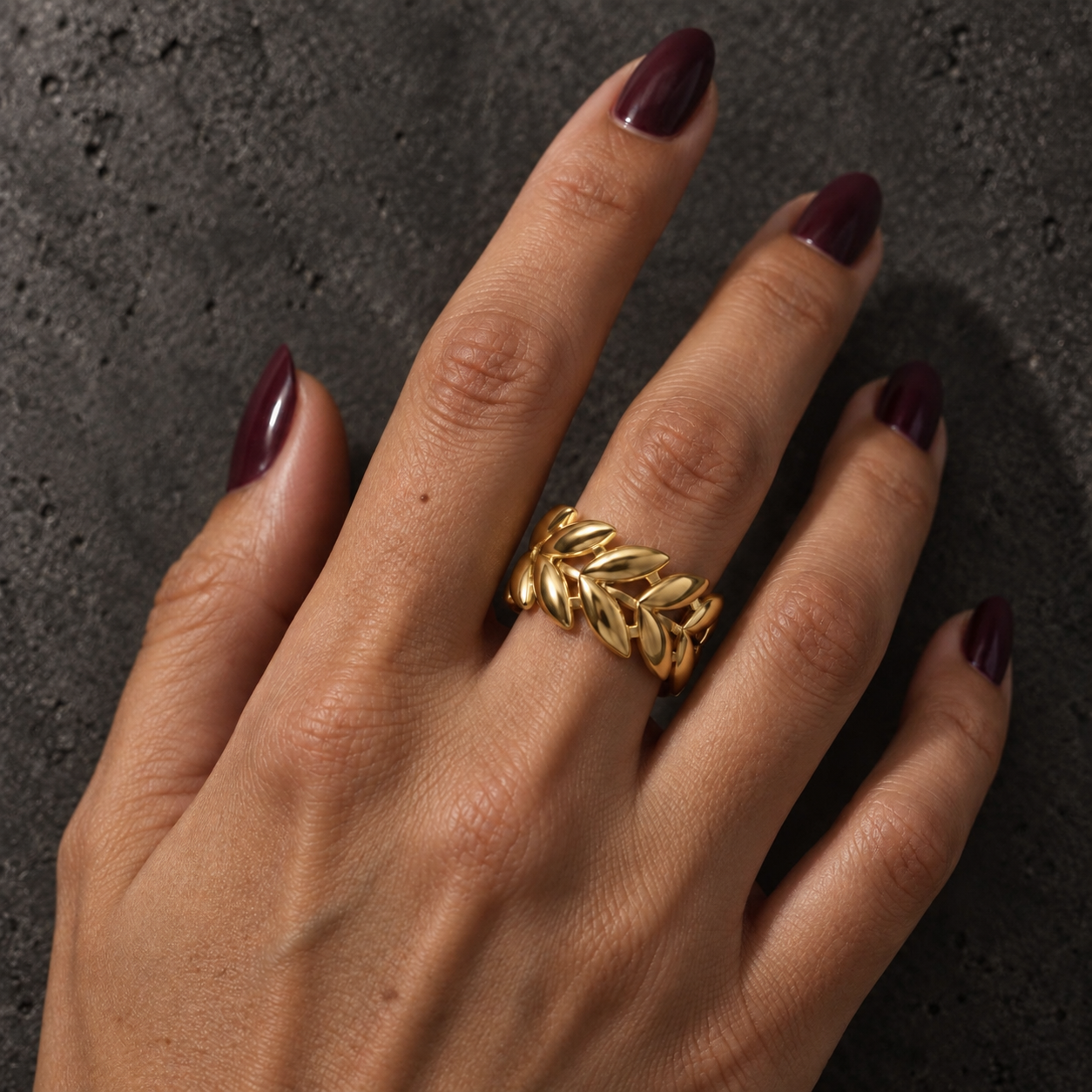 Anillo Laurel dorado ajustable de acero 316L puesto en una mano real