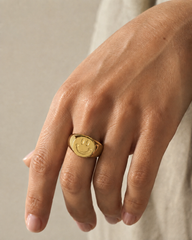 Anillo Smiley dorado puesto en una mano, fotografía editorial