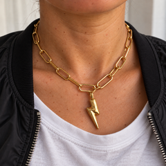 Collar Fulmen dorado de 45 cm sobre piel con textura natural, con bomber negra y camiseta blanca