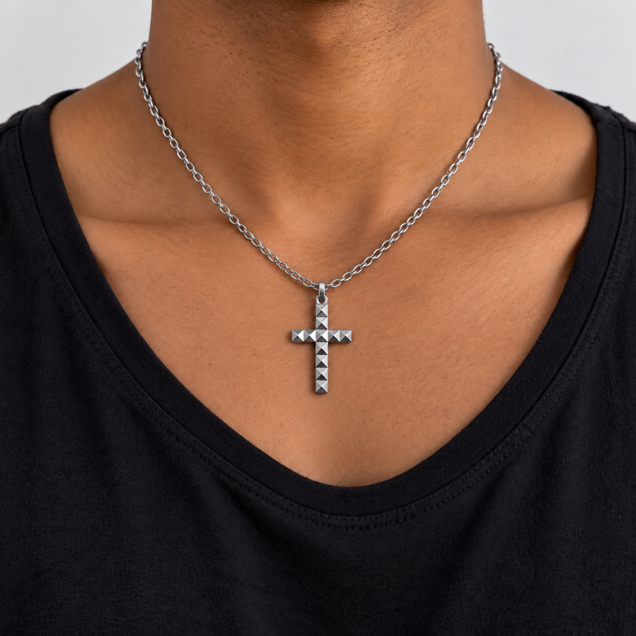 Collar Heresy de acero plateado con pequeña cruz de tachuelas sobre cuello moreno