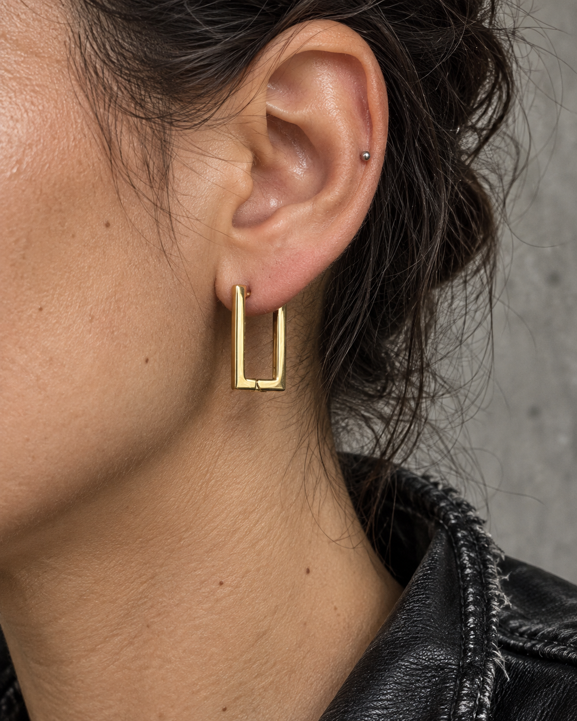 Pendientes Frame Click dorados de acero 316L puestos en una oreja