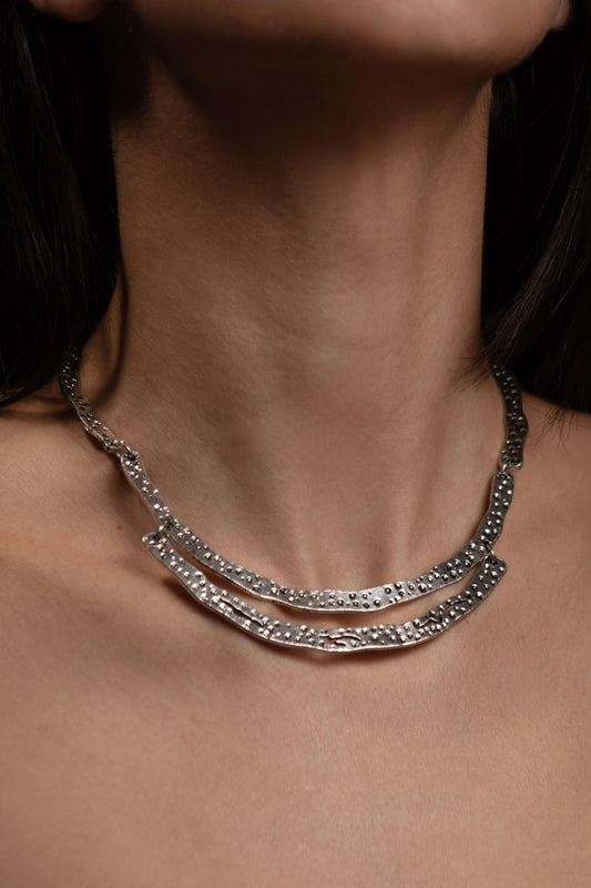 Collar Veneno plateado de edición limitada puesto en el cuello