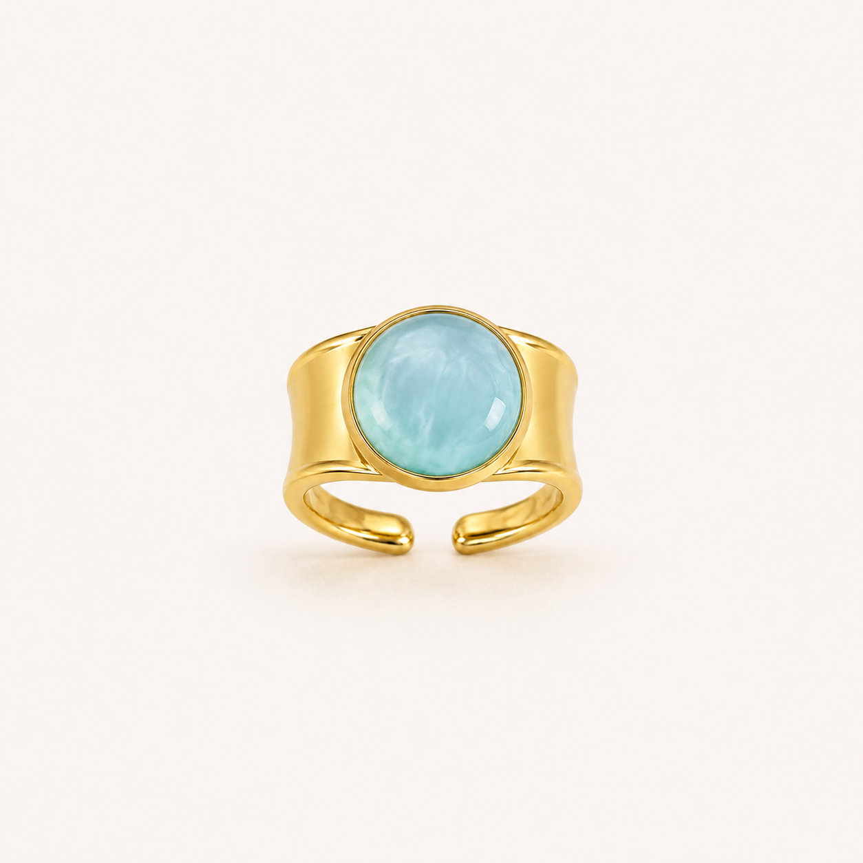 Anillo Bruma dorado ajustable con cabujón azul claro sobre fondo blanco