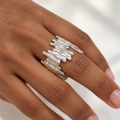 Anillo Distorsión plateado ajustable de relieve ondulado en una mano morena