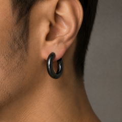 Aro Blackout grande pavonado negro centrado en el lóbulo de una oreja masculina