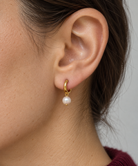 Aro Pearl Crush dorado de 9 mm con perla colgante en una oreja vista de perfil