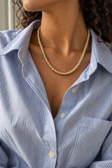 Collar Desfase de 45 cm sobre cuello de piel morena con camisa de rayas