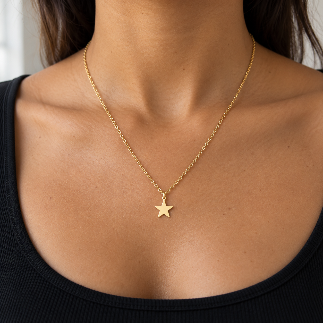 Collar Estelar dorado con estrella pequeña y cadena de 45 cm sobre cuello moreno