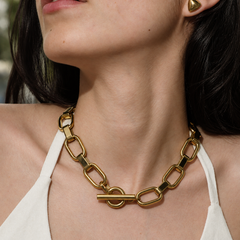Collar Interlinked dorado de ALMADIVERSA sobre cuello con luz natural y cierre frontal de barra y argolla abrochado
