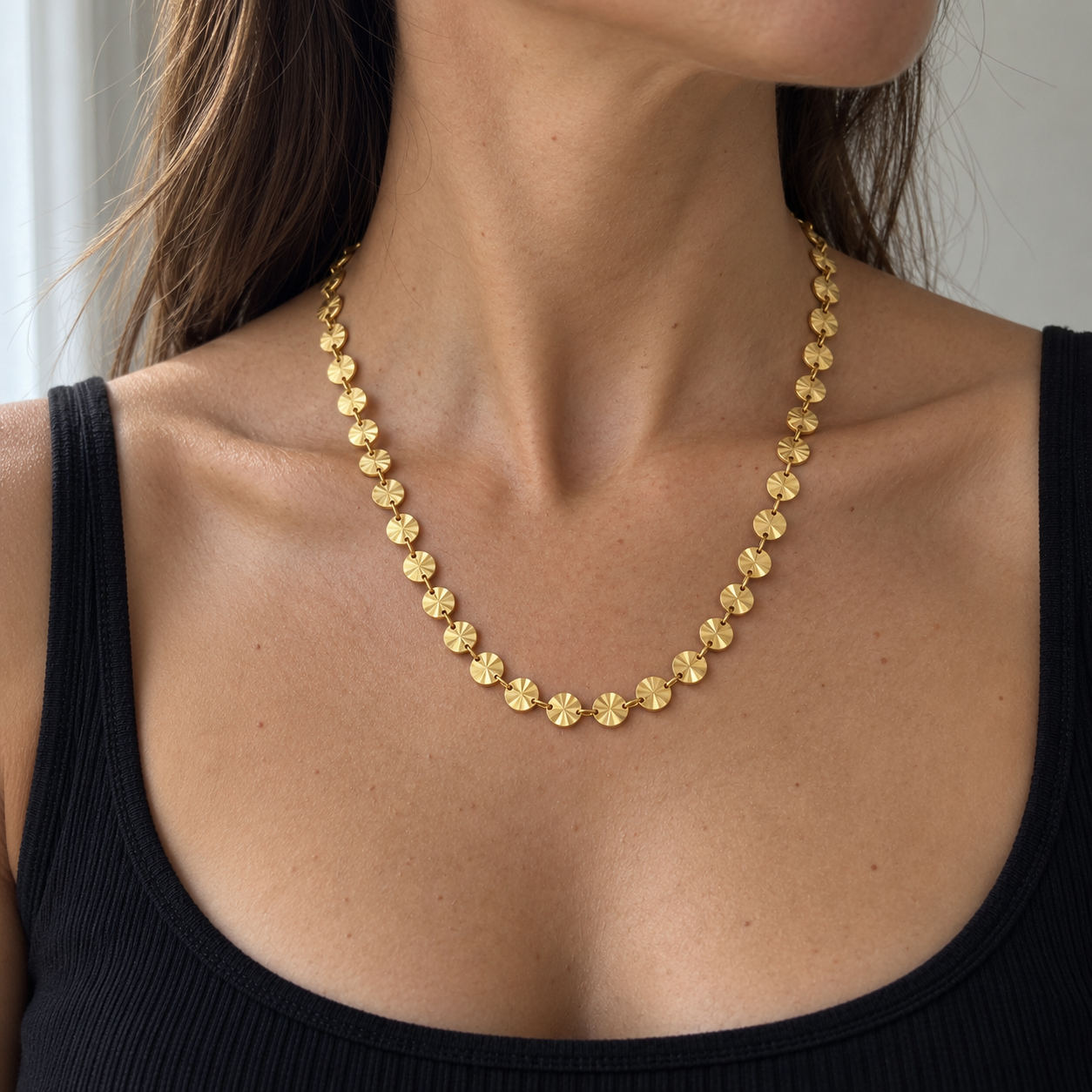 Collar Sunbeat dorado de discos con relieve radial sobre cuello con camiseta negra